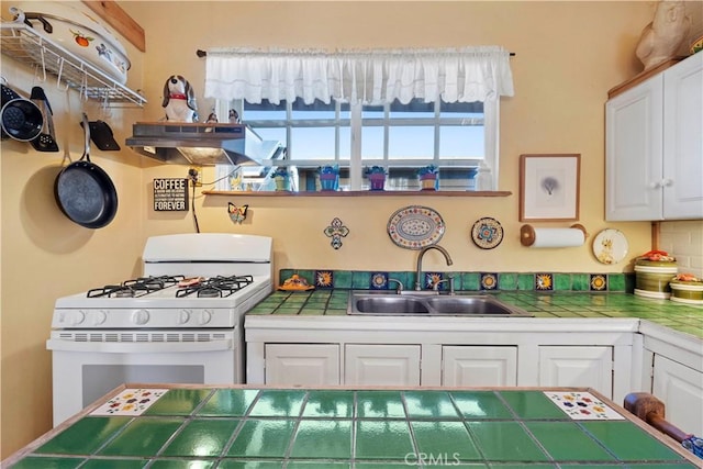 kitchen featuring sink, white cabinetry, white range with gas stovetop, and tile countertops