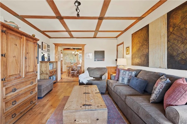 living room featuring hardwood / wood-style flooring, beam ceiling, a chandelier, and coffered ceiling