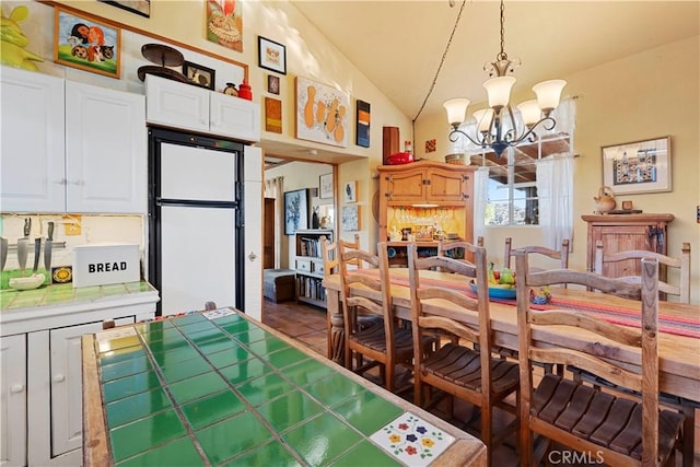 dining space featuring vaulted ceiling and a notable chandelier