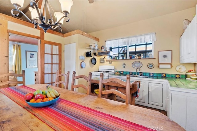 dining space featuring french doors and a chandelier