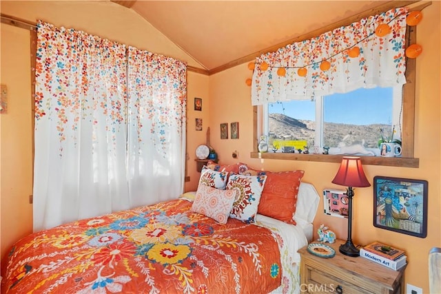 bedroom with lofted ceiling, crown molding, and a mountain view