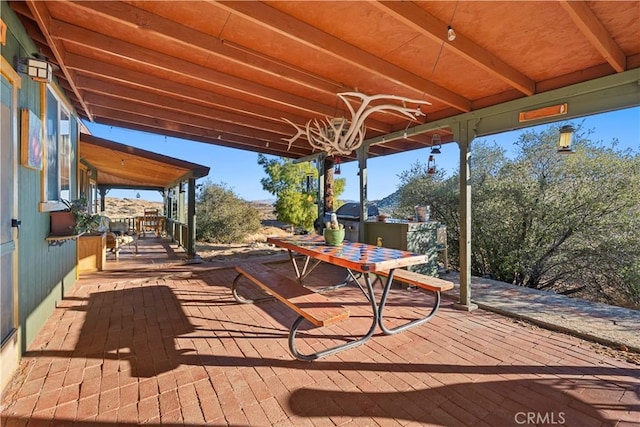 wooden deck featuring area for grilling and a patio