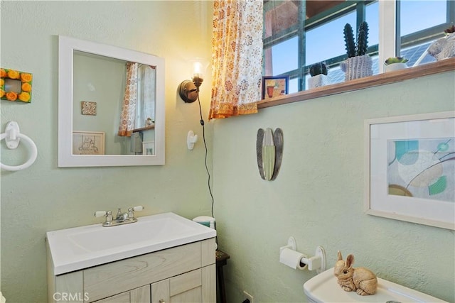 bathroom featuring toilet, plenty of natural light, and vanity