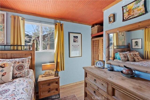 bedroom with light wood-type flooring and wooden ceiling