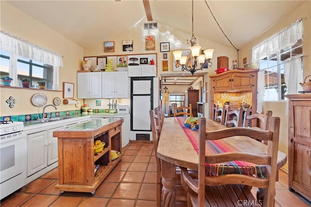 kitchen featuring white cabinetry, white range with gas stovetop, fridge, a notable chandelier, and hanging light fixtures