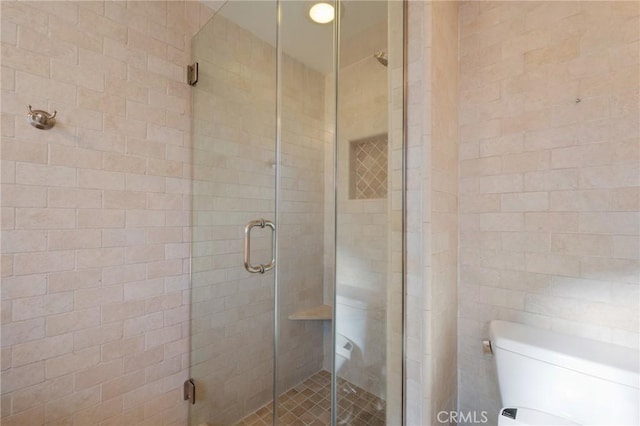 bathroom featuring an enclosed shower and toilet