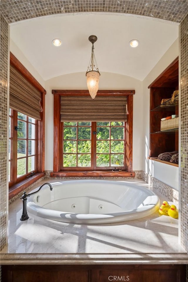 bathroom with lofted ceiling and a bath