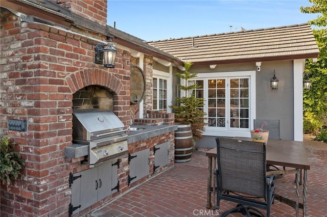 view of patio with area for grilling and a fireplace