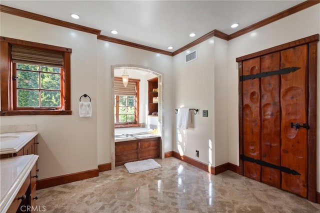 bathroom featuring vanity, ornamental molding, and a bath