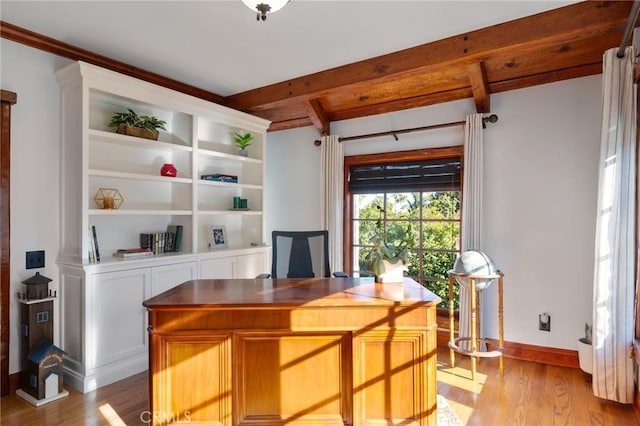 office area with light wood-type flooring and beam ceiling