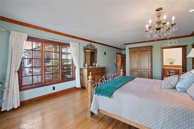 bedroom with light wood-type flooring, crown molding, and a chandelier