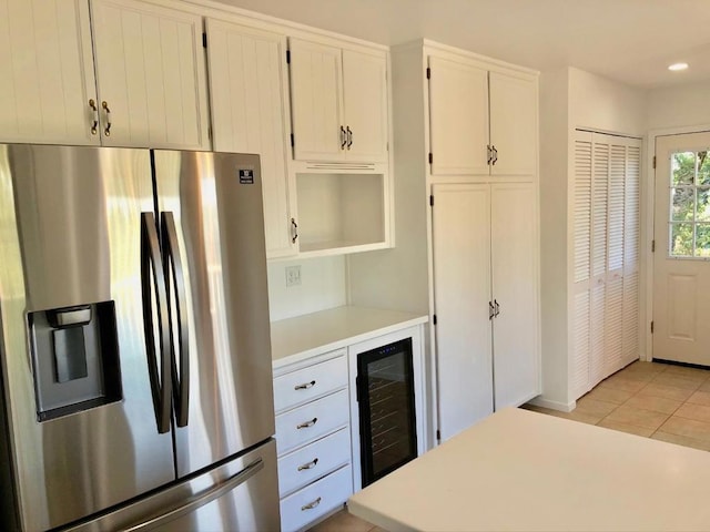 kitchen with white cabinetry, light tile patterned floors, wine cooler, and stainless steel fridge