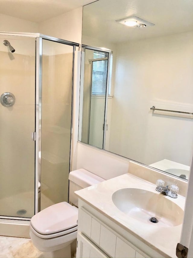 bathroom featuring vanity, an enclosed shower, and toilet