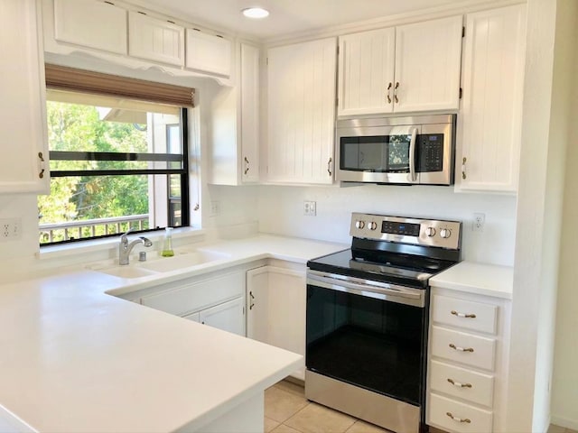 kitchen featuring stainless steel appliances, white cabinetry, sink, and light tile patterned floors