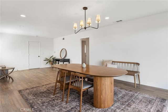 dining space featuring dark hardwood / wood-style flooring and a notable chandelier