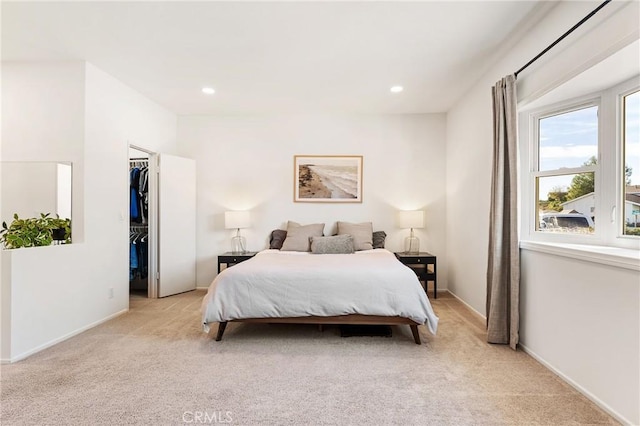 bedroom featuring a spacious closet and light colored carpet