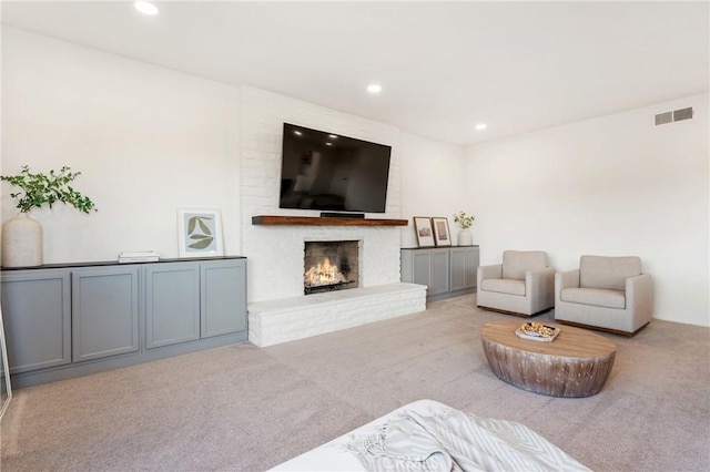 living room with light colored carpet and a brick fireplace