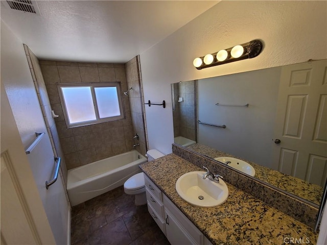 full bathroom featuring toilet, tiled shower / bath, and vanity