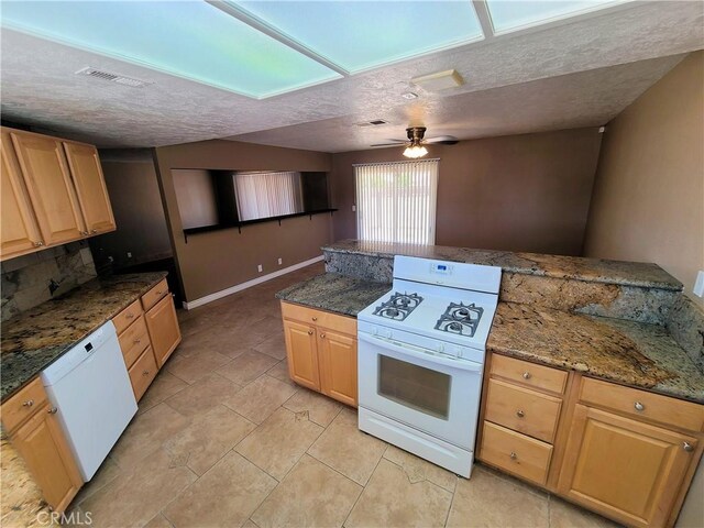 kitchen featuring ceiling fan, dark stone countertops, white appliances, and a textured ceiling