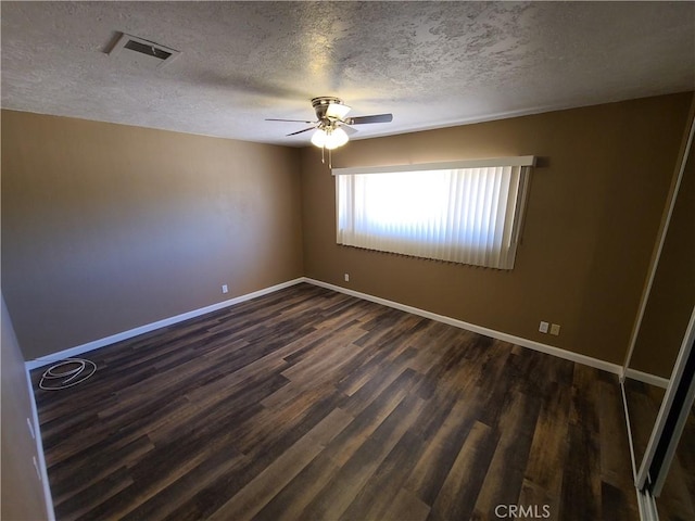 spare room with ceiling fan, dark wood-type flooring, and a textured ceiling