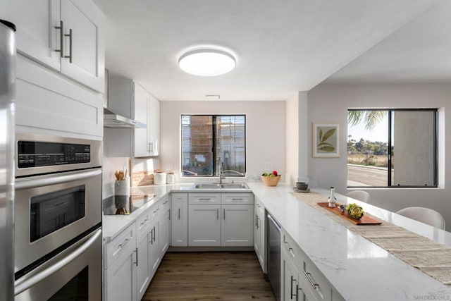 kitchen featuring white cabinets, double oven, sink, light stone counters, and black electric cooktop