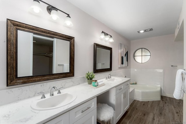 bathroom featuring a bathing tub, wood-type flooring, and vanity