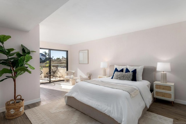 bedroom featuring access to exterior and hardwood / wood-style floors