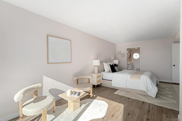 bedroom with wood-type flooring and ensuite bath