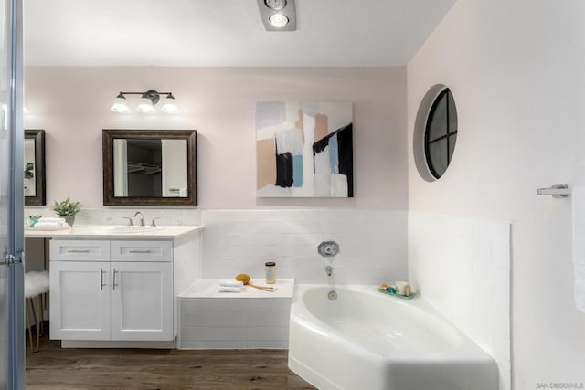 bathroom with vanity, hardwood / wood-style flooring, and a bath