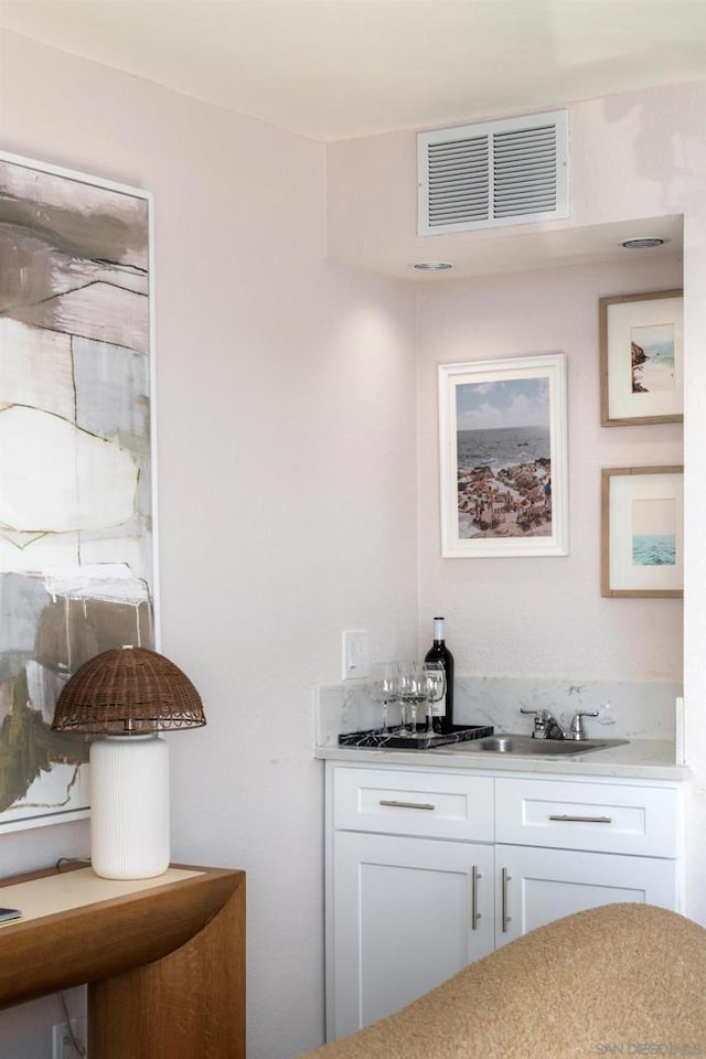 bar featuring white cabinetry and sink