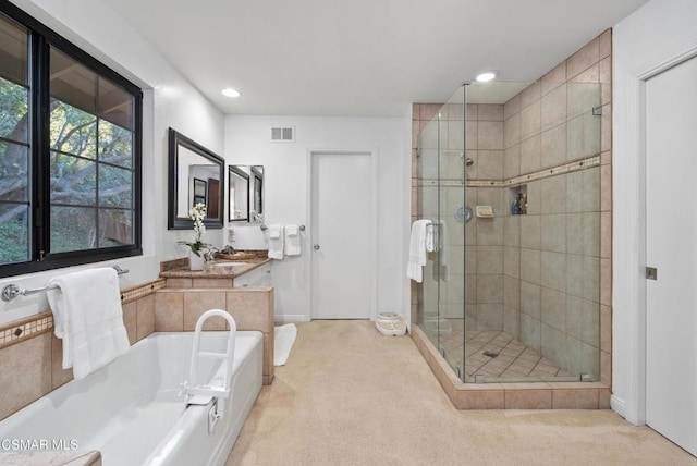 bathroom featuring vanity and independent shower and bath