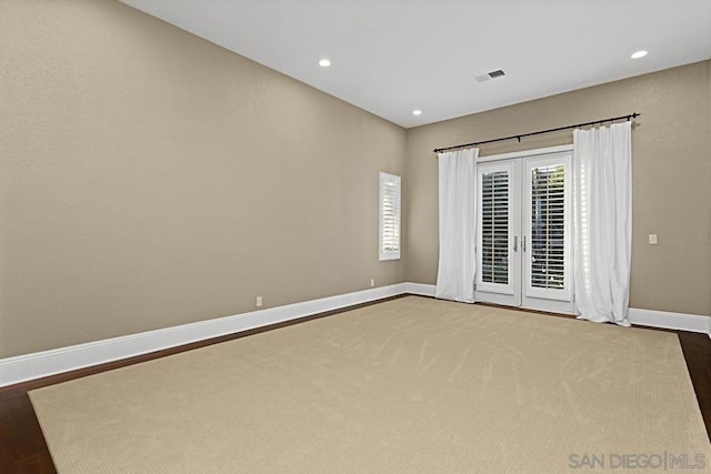 empty room with hardwood / wood-style flooring and french doors