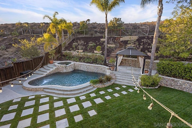 view of pool featuring a gazebo, an in ground hot tub, and a lawn