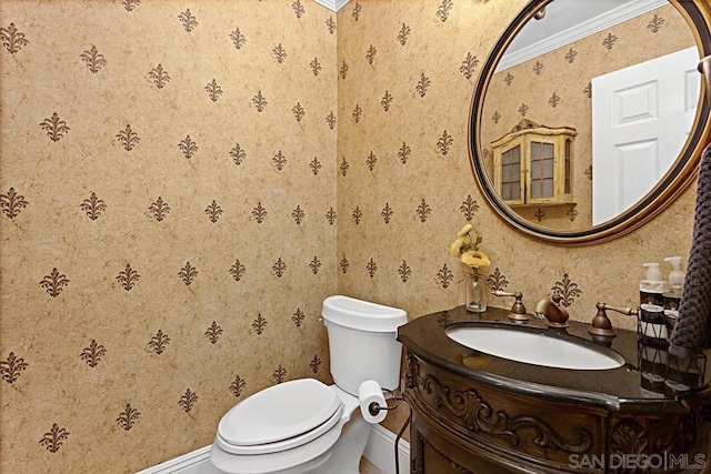 bathroom with toilet, ornamental molding, and vanity