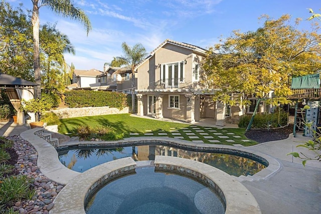 view of pool with an in ground hot tub, a patio area, and a yard