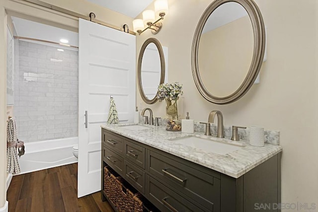 full bathroom with wood-type flooring, toilet, vanity, and tiled shower / bath