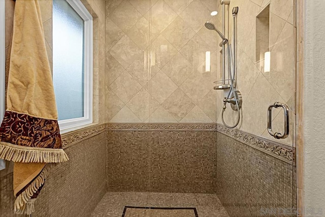 bathroom featuring tile walls and a shower with door