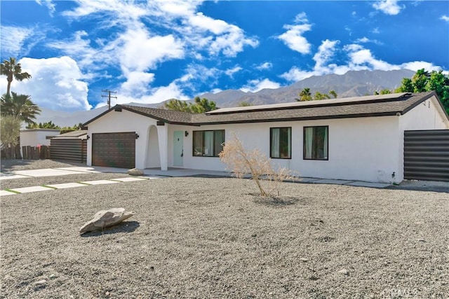 ranch-style home with a garage and a mountain view