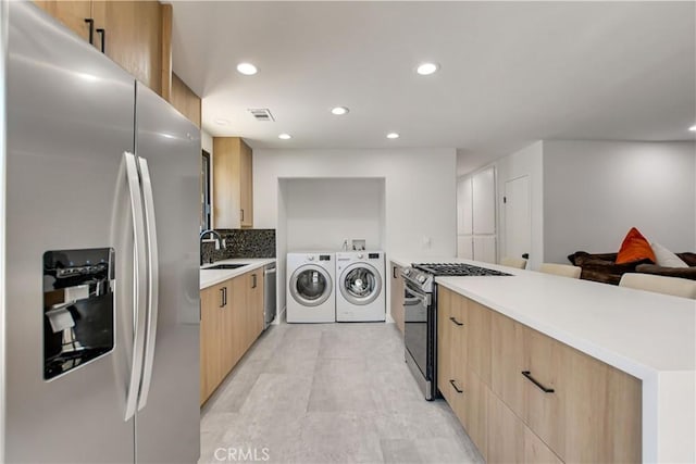 clothes washing area featuring sink and independent washer and dryer