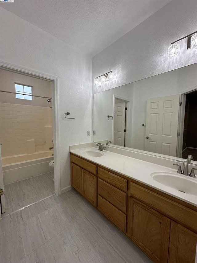 full bathroom with a textured ceiling, shower / tub combination, vanity, and toilet