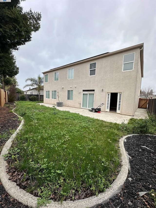 rear view of property with a yard and a patio