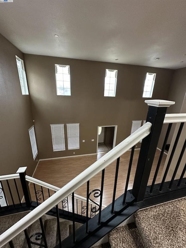 stairs featuring hardwood / wood-style floors and plenty of natural light