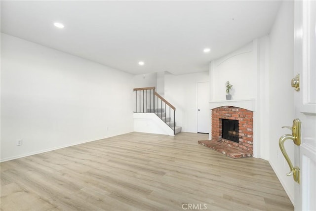 unfurnished living room with a fireplace and light wood-type flooring