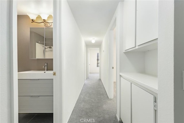 corridor featuring sink and light carpet