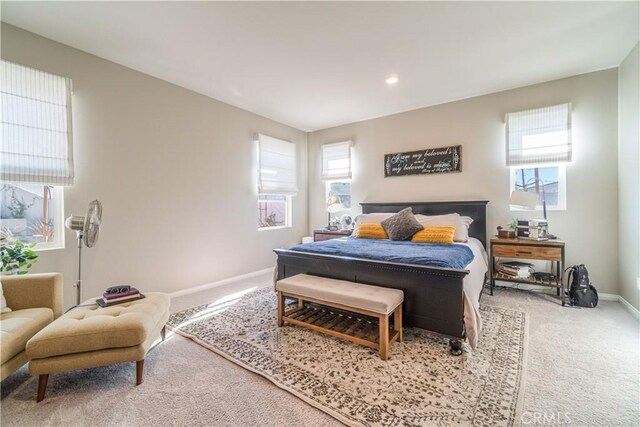 bedroom featuring light carpet and multiple windows