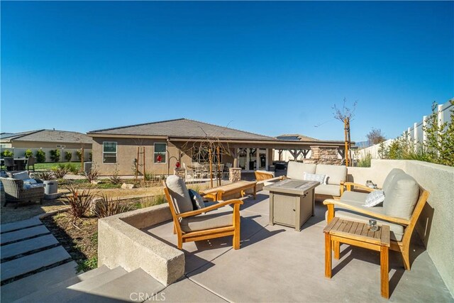 view of patio featuring an outdoor living space with a fire pit