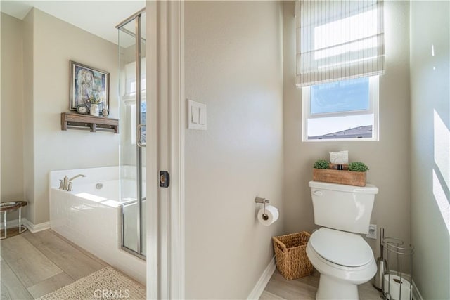 bathroom with plenty of natural light, hardwood / wood-style floors, toilet, and plus walk in shower