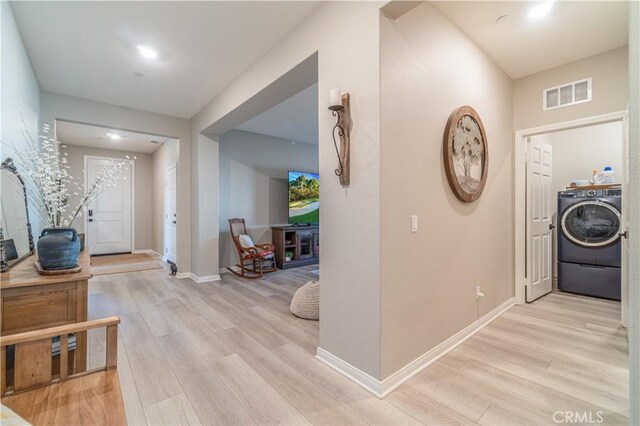 entrance foyer with light wood-type flooring and washer / clothes dryer