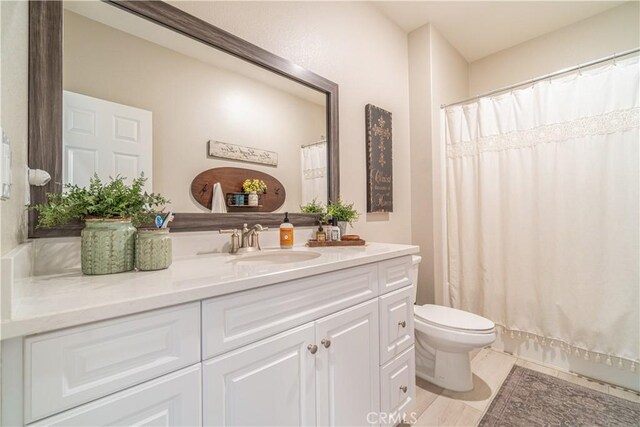 bathroom with toilet, walk in shower, and vanity