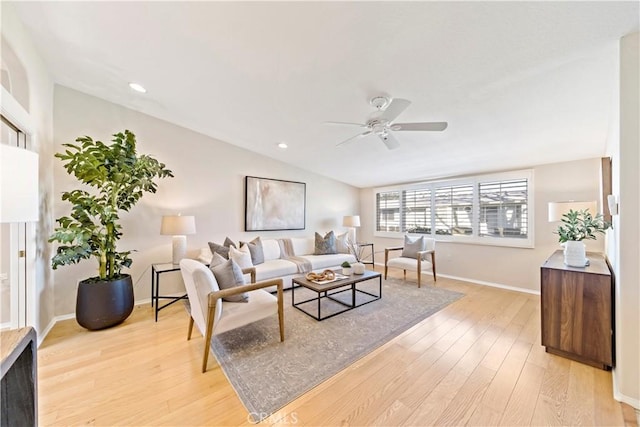 living room featuring ceiling fan, light hardwood / wood-style flooring, and lofted ceiling